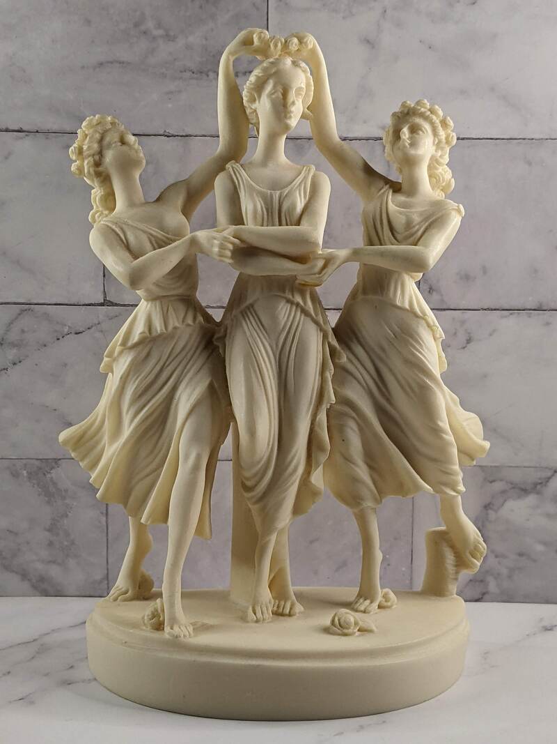 A tabletop sculpture of three dancing women.