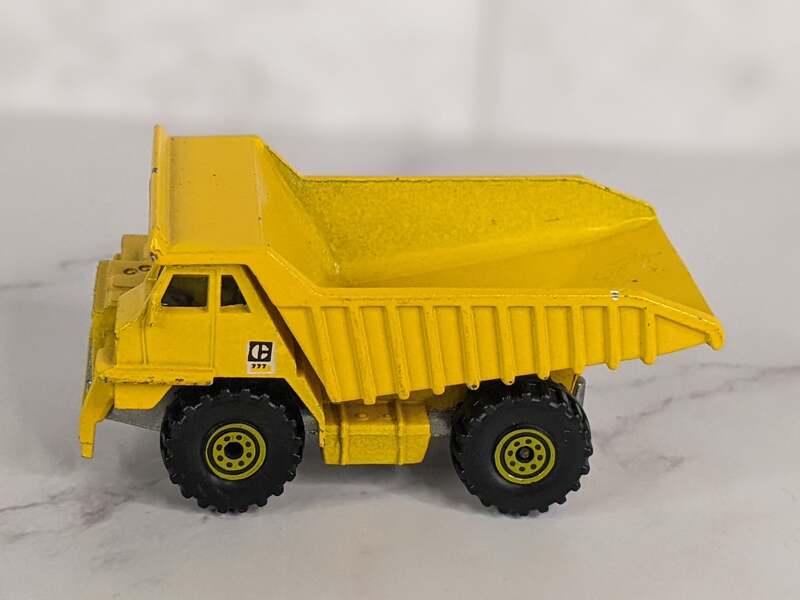 A yellow dump truck Hot Wheels toy from 1979 with black tires.